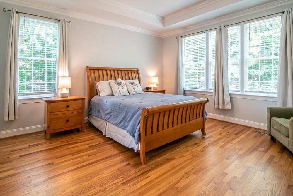 A bedroom with warm oak flooring in a Bowness bungalow.