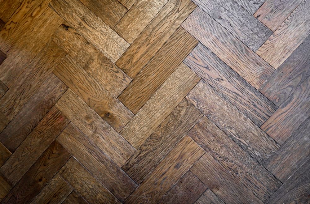 Close detail of stained herringbone oak flooring.