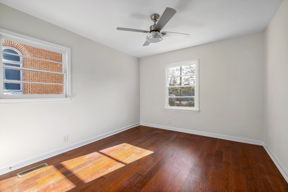 An empty Killarney bungalow room with dark oak strip flooring.