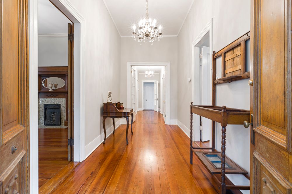 A hallway with rich wood flooring in a large Mount Royal home.